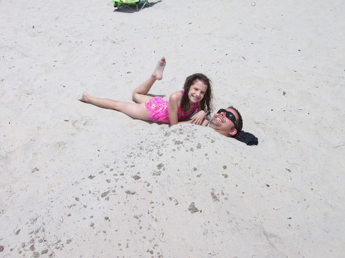 Anna burying Michael in the sand