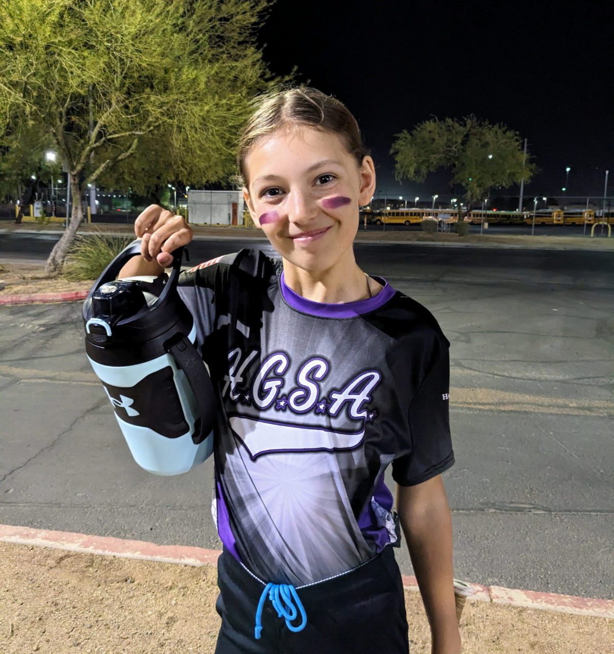 Ava holding her new softball water bottle before practice