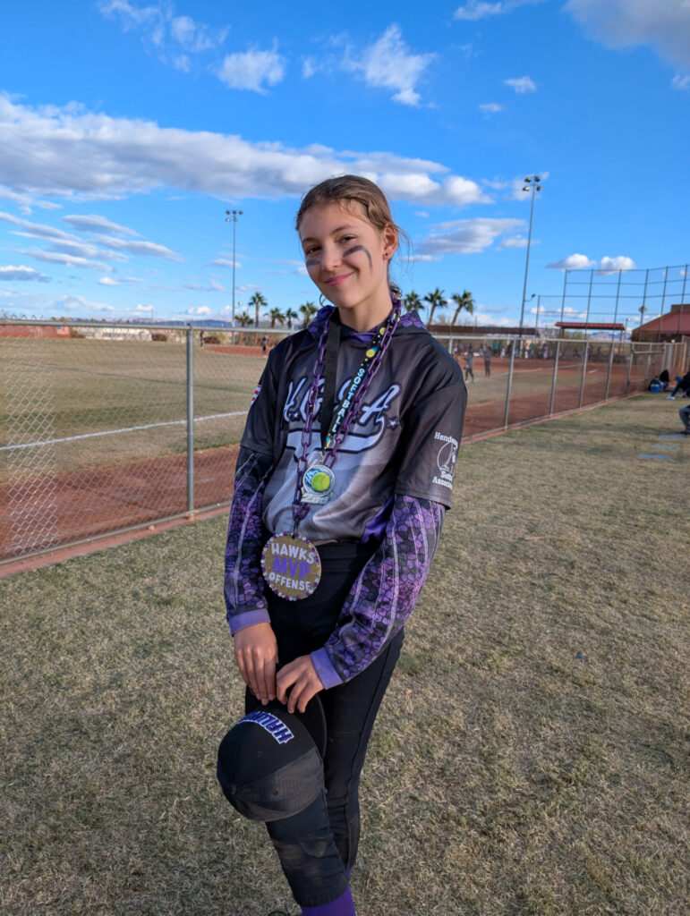 Ava with her Offensive MVP award after the final softball game of the season