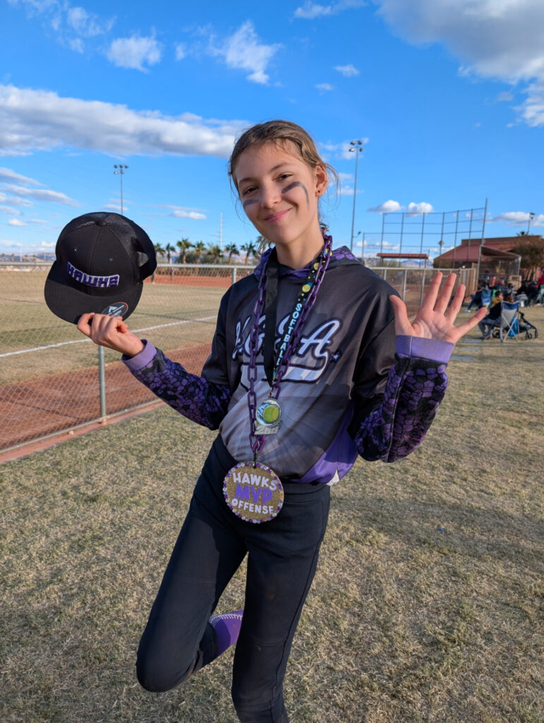 Ava with her Offensive MVP award after the final softball game of the season