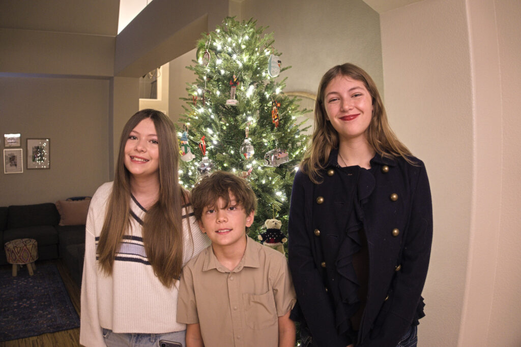 Elise, Enzo, and Ava Pellegrini in front of their 2025 Christmas tree