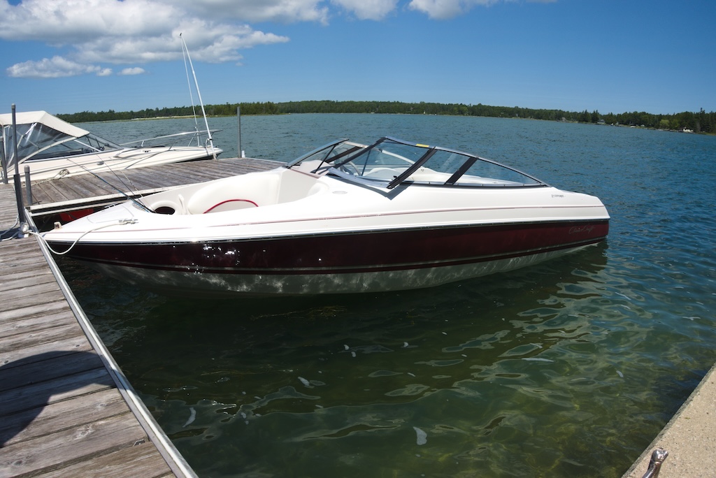 A speed boat and a fishing boat docked on Lake Huron